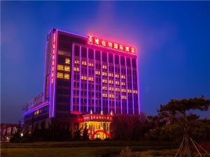 budynek jest oświetlony niebiesko-czerwonym w obiekcie Vienna International Hotel Shandong Weihai Rongcheng w mieście Rencheng