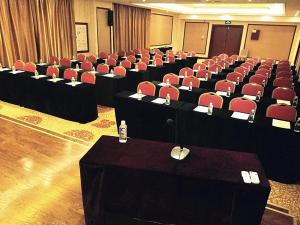 una sala de conferencias con escritorios y sillas rojas en Vienna International Hotel Shandong Weihai Rongcheng, en Rongcheng