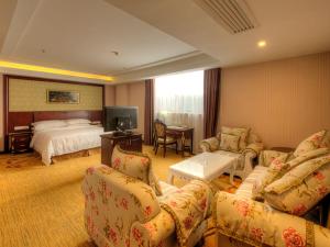 a hotel room with a bed and a couch and chairs at Vienna Hotel Shanghai Happy Valley in Songjiang