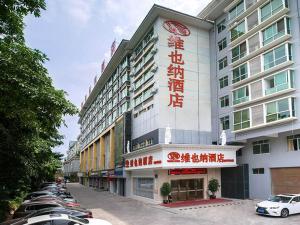 a hotel with cars parked in a parking lot at Vienna Hotel Nanning Qingxiu Mountain in Nanning