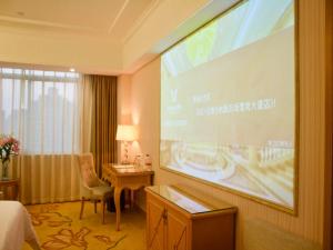 a large screen in a hotel room with a presentation at Vienna Hotel Banxuegang Road in Longgang