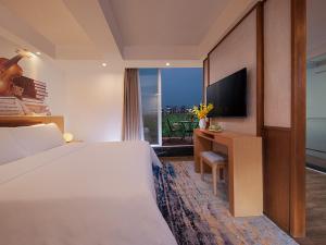 a hotel room with a bed and a television at Vienna 3 Best Hotel Beihai Sichuan Road in Beihai