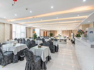 una sala per banchetti con tavoli e sedie in una stanza di Vienna Hotel Zhengzhou Airport a Zhengzhou