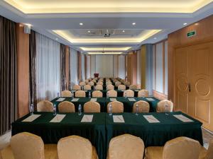uma sala de conferências com uma grande mesa e cadeiras em Vienna Hotel Shenzhen Buji Ganli Road em Longgang