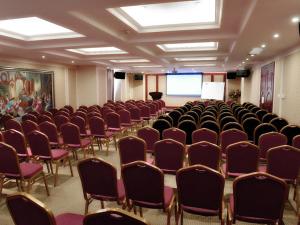 a large room with a bunch of chairs and a screen at Vienna Hotel Songgang Yanchuan Road in Bao'an