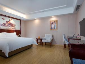 a hotel room with a bed and a desk and chair at Vienna hotel ( maanshan park post golden eagle international shop) in Ma'anshan +4 photos