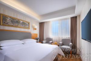 une chambre d'hôtel avec un lit et une télévision dans l'établissement Vienna 3 good hotel (Anhui Ningguo store), à Ningguo