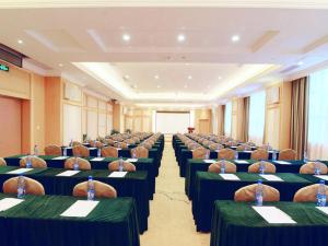 Cette grande chambre comprend des rangées de tables et de chaises. dans l'établissement Vienna Hotel Hunan Yongzhou Lengshuitan District Government Square, à Guzhuting