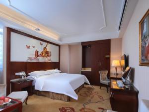 a hotel room with a large bed and a desk at Vienna Classic Hotel Nanchang Jiefang West Road in Nanchang