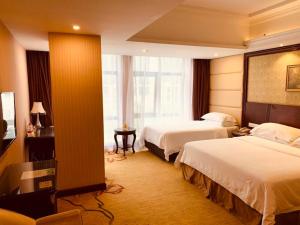 Posteľ alebo postele v izbe v ubytovaní Vienna Hotel Shanghai Happy Valley