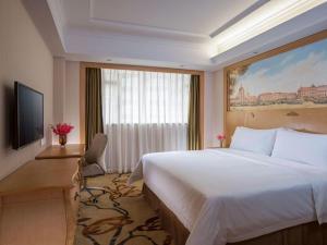 a hotel room with a large bed and a window at Vienna Hotel Shenzhen Nanshan Yilida in Shenzhen