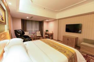 a hotel room with a bed and a flat screen tv at Vienna Hotel Nanning Qingxiu Mountain in Nanning