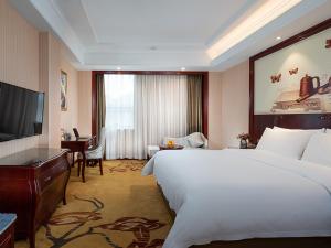 a hotel room with a large bed and a television at Vienna hotel ( maanshan park post golden eagle international shop) in Ma'anshan