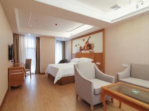 a hotel room with a bed and a couch and chairs at Vienna Hotel Nanjing Olympic Sports Center in Nanjing