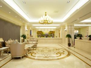 a lobby with chairs and a chandelier in a building at Vienna International Hotel Xian High Technology Road in Xi'an
