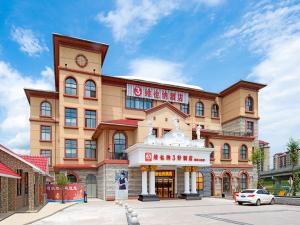 a large building with a clock on top of it at Vienna 3 Best Hotel (Ganzhou shangyou store) in Yuanzicha