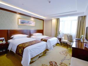 מיטה או מיטות בחדר ב-Vienna Hotel Shanghai Zhongqiao Institute