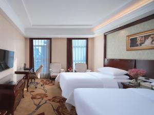 南京维也纳酒店江苏南京百家湖西门子店的一间有两张床和一台平板电视的酒店房间 更多6张照片