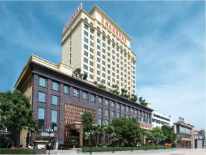 een groot gebouw met een bord erop bij Vienna International Hotel Dongguan Changping Swan Lake Road in Dongguan