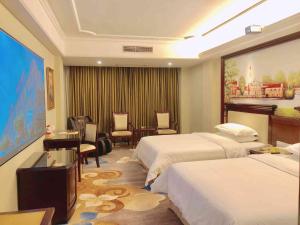 a hotel room with two beds and a table and chairs at Vienna Hotel Guangzhou Shiling in Huadu +4 photos