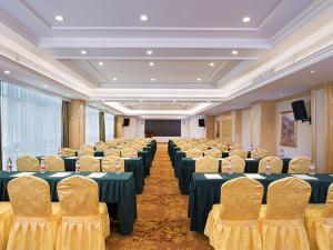 une salle de conférence avec des tables, des chaises et un écran dans l'établissement Vienna Hotel Guangxi Nanjing Nanhu Park, à Nanning