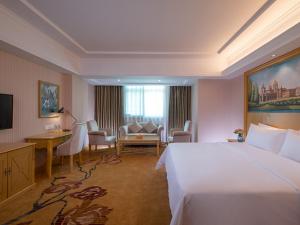 Habitación de hotel con cama grande y escritorio. en Vienna Hotel Shenzhen Luofang, en Shenzhen