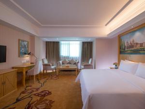 a hotel room with a large bed and a desk at Vienna Hotel Shenzhen Luofang in Shenzhen