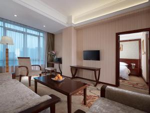 a living room with a couch and a table in a hotel room at Vienna Hotel Guangzhou Shaheding Metro Station in Guangzhou