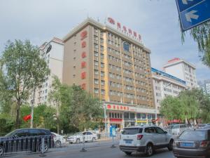 duży budynek z samochodami zaparkowanymi przed nim w obiekcie Vienna Hotel Xining Shengli Road w mieście Xining