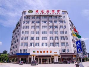 Un grand bâtiment blanc avec un panneau en haut dans l'établissement Vienna Hotel Guilin ShiFu Branch, à Lingui