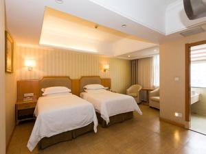 pokój hotelowy z 2 łóżkami i kanapą w obiekcie Vienna 3 Best Hotel Hubei Jingmen Huyaguan Avenue Changfa w mieście Jingmen