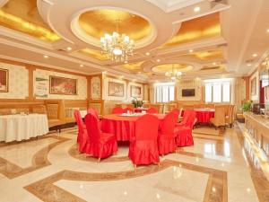 una gran sala de banquetes con mesas y sillas rojas en Vienna Hotel Shanghai Zhongqiao Institute, en Zhangyan
