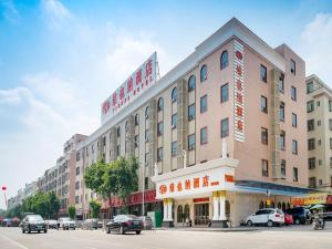 a large building on a city street with cars parked at Vienna Hotel Guangzhou Shiling in Huadu