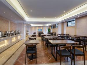 un restaurante con mesas y sillas en una habitación en Vienna International Hotel Dongguan Shilonghuixing Business Central, en Dongguan