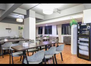 une salle à manger avec des tables et des chaises ainsi qu'une cuisine dans l'établissement Vienna Hotel Shenzhen East Railway Station, à Shenzhen