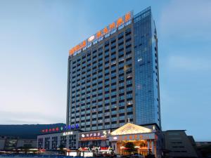 a tall building with a restaurant in front of it at Vienna Hotel Shaoguan Wuli Pavilion in Shaoguan