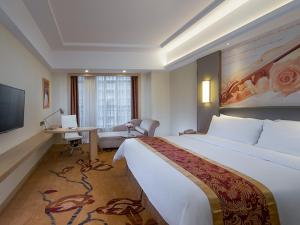 Habitación de hotel con cama grande y escritorio. en Vienna International Hotel Dongguan Shilonghuixing Business Central, en Dongguan