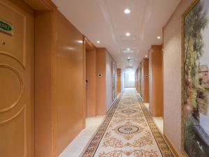 a hallway with a tile floor in a building with a corridorngthngthngthngth at Vienna Hotel (Huizhou Daya Bay Xinyi Store) in Huizhou