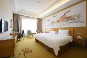嘉定区にあるVienna International Hotel Shanghai Malu Stationの大きなベッドとデスクが備わるホテルルームです。