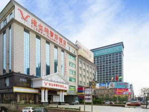 a large building on a city street with buildings at Vienna 3 Best Hotel Guangzhou Zengcheng Xintang Harbour Avenue in Zengcheng