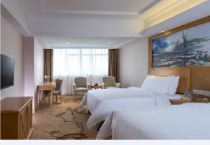 a hotel room with two beds and a television at Vienna International Hotel Guangdong Foshan Nanhai Heshun in Nanhai