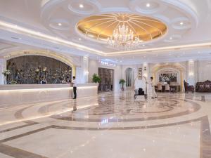Xinyi的住宿－維也納國際酒店茂名信宜新尚路店，大型客房设有吊灯和大型大堂。