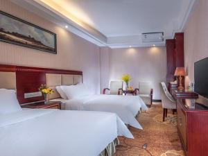 a hotel room with two beds and a television at Vienna Hotel Longgang Nanlian in Longgang