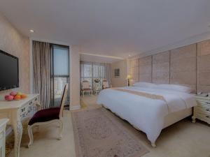 Un dormitorio grande con una cama grande y un televisor. en Vienna Hotel Shenzhen Henggang New City, en Longgang 25 fotos más