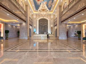 a large lobby with a chandelier in a building at Vienna International Hotel Guangzhou Jiaokou Subway Station in Nanhai