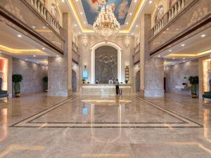 NanhaiにあるVienna International Hotel Guangzhou Jiaokou Subway Stationの建物内のシャンデリアのある広いロビー