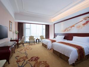 Xinyi的住宿－維也納國際酒店茂名信宜新尚路店，酒店客房配有两张床和一张书桌