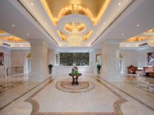 a large lobby with a chandelier and a table in it at Vienna International Hotel Dongguan Chang'an North Station in Dongguan