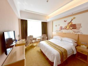 西寧市にあるVienna Hotel Xining Shengli Roadの大型ベッドとテレビが備わるホテルルームです。