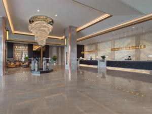 un vestíbulo de un hotel con una lámpara de araña en Vienna International Hotel Diecai Wanda High Speed ​​Rail Station en Guilin